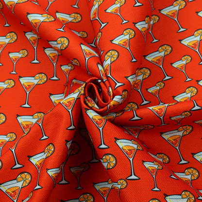A repeating pattern of cocktail glasses filled with orange liquid, garnished with a slice of orange and a cherry, set against a bright red background.