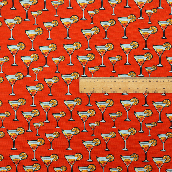 A repeating pattern of cocktail glasses filled with orange liquid, garnished with a slice of orange and a cherry, set against a bright red background.