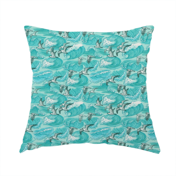 The fabric used to create this handmade cushion is a repeating pattern of crashing ocean waves and soaring seagulls rendered in shades of teal and white.
