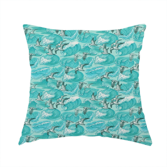 The fabric used to create this handmade cushion is a repeating pattern of crashing ocean waves and soaring seagulls rendered in shades of teal and white.
