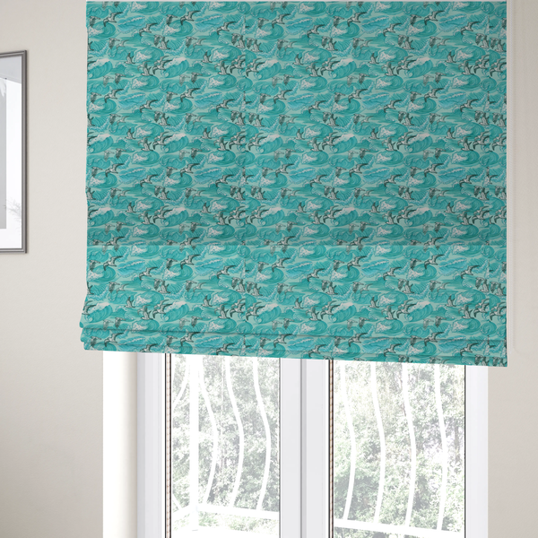 The fabric used to create these Roman blinds is a repeating pattern of crashing ocean waves and soaring seagulls rendered in shades of teal and white.