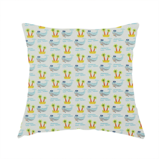 The fabric used to create this handmade cushion is a repeating pattern of small blue whales wearing captain's hats swimming near tiny tropical islands with palm trees, set against a light grey background with small blue wave lines.