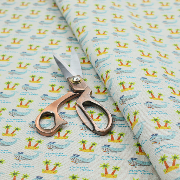 A repeating pattern of small blue whales wearing captain's hats swimming near tiny tropical islands with palm trees, set against a light grey background with small blue wave lines.