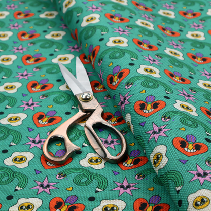 A repeating pattern of quirky, cartoonish motifs including smiling eggs, stylized red hearts with faces, wiggly green pencils, and pink star-like shapes on a teal background.