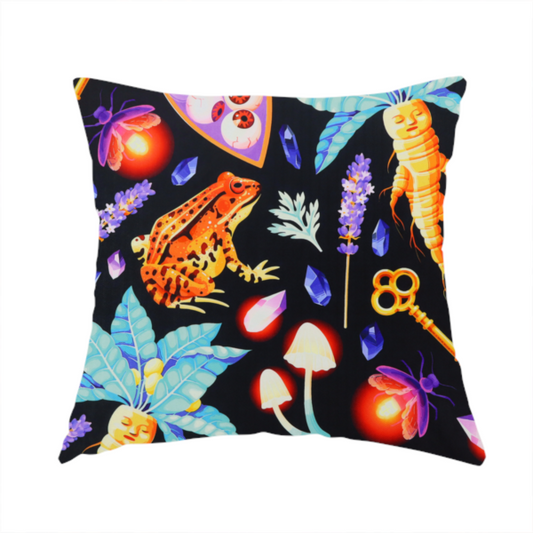 The fabric used to create this handmade cushion is a vibrant, repeating mystical pattern on a black background featuring illustrated mandrake roots with faces, orange frogs, purple moths, glowing fireflies, potion bottles filled with eyeballs, ornate golden keys, luminescent mushrooms, lavender sprigs, and scattered crystals.