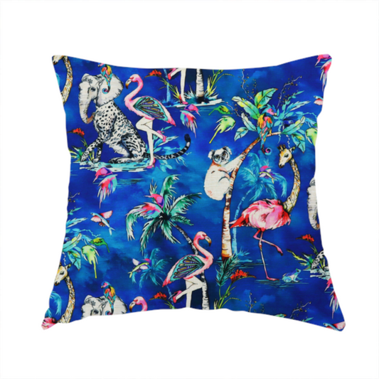 The fabric used to create this handmade cushion is a whimsical tropical pattern featuring colourful flamingos, giraffes, leopards, elephants, and koalas amidst lush foliage on a vibrant blue background.