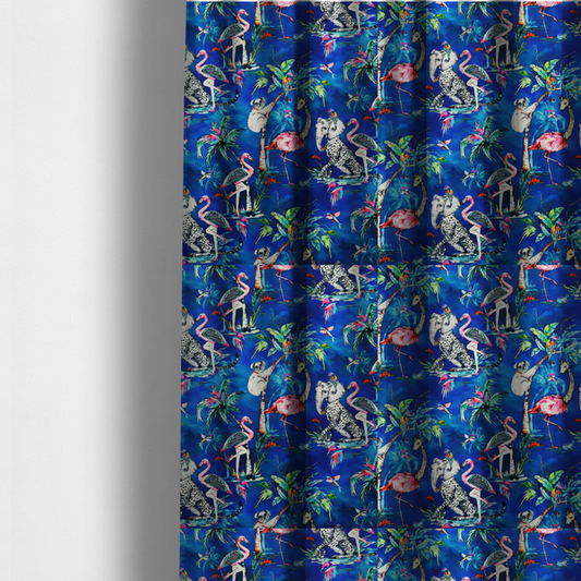 The fabric used to create these made-to-measure curtains is a whimsical tropical pattern featuring colourful flamingos, giraffes, leopards, elephants, and koalas amidst lush foliage on a vibrant blue background.