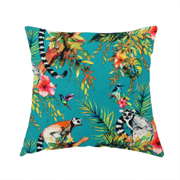 The fabric used to create this handmade cushion is a playful tropical pattern featuring ring-tailed lemurs, hummingbirds, and exotic flowers amongst lush green foliage on a bright turquoise background.