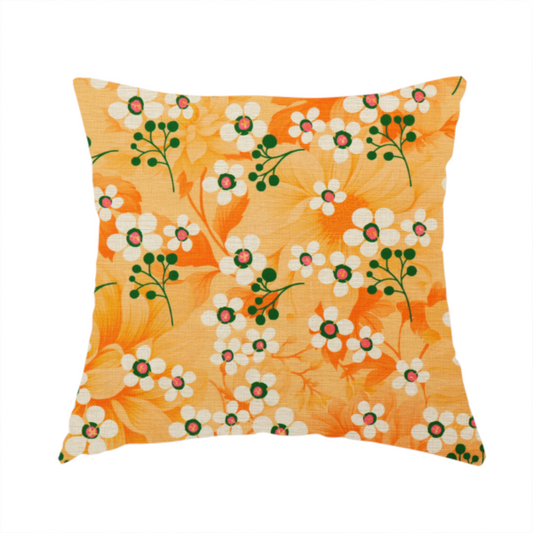 The fabric used to create this handmade cushion is a retro floral pattern featuring delicate white flowers, green branching stems, and large orange botanical motifs set against a warm yellow background.