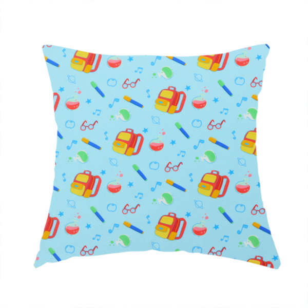 The fabric used to create this handmade cushion is a seamless repeating school-themed pattern featuring backpacks, beakers, glasses, pens, and musical notes scattered over a light blue background.