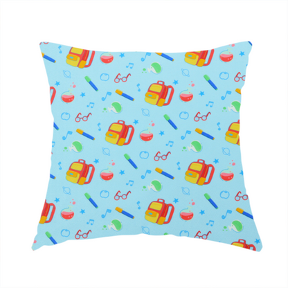 The fabric used to create this handmade cushion is a seamless repeating school-themed pattern featuring backpacks, beakers, glasses, pens, and musical notes scattered over a light blue background.