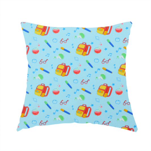 The fabric used to create this handmade cushion is a seamless repeating school-themed pattern featuring backpacks, beakers, glasses, pens, and musical notes scattered over a light blue background.