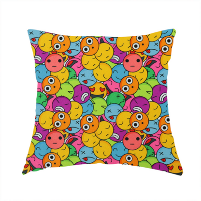 The fabric used to create this handmade cushion is a dense, overlapping pattern of colourful, stylized emoji faces displaying various cartoonish expressions, including winking, laughing, dizzy, and neutral expressions, in a vibrant mix of yellow, orange, blue, green, and pink.
