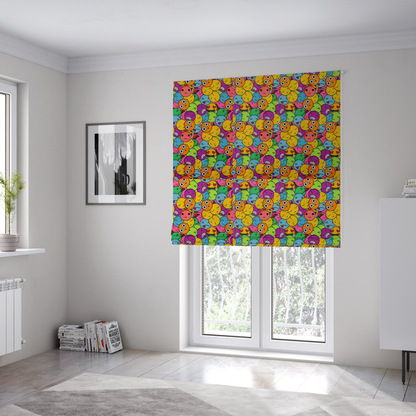 The fabric used to create these Roman blinds is a dense, overlapping pattern of colourful, stylized emoji faces displaying various cartoonish expressions, including winking, laughing, dizzy, and neutral expressions, in a vibrant mix of yellow, orange, blue, green, and pink.