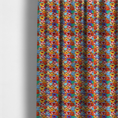 The fabric used to create these made-to-measure curtains is a dense, overlapping pattern of colourful, stylized cartoon faces featuring wide smiles, sticking-out tongues, and various cheerful or cheeky expressions in vibrant shades of pink, orange, yellow, blue, and purple.