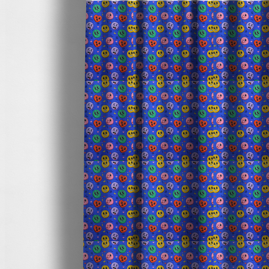 The fabric used to create these made-to-measure curtains is a repeating pattern of quirky cartoon characters, including winking faces, hearts, green blobs, and dizzy expressions with X eyes, scattered over a blue grid background.