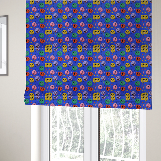 The fabric used to create these Roman blinds is a repeating pattern of quirky cartoon characters, including winking faces, hearts, green blobs, and dizzy expressions with X eyes, scattered over a blue grid background.