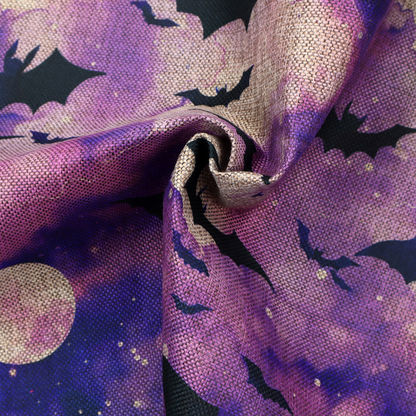 A watercolour-style Halloween fabric featuring a spooky night sky in shades of purple and pink, filled with silhouettes of flying black bats and two pale full moons.