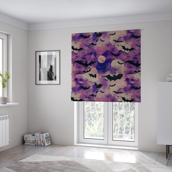 The fabric used to create these Roman blinds is a watercolour-style Halloween fabric featuring a spooky night sky in shades of purple and pink, filled with silhouettes of flying black bats and two pale full moons.