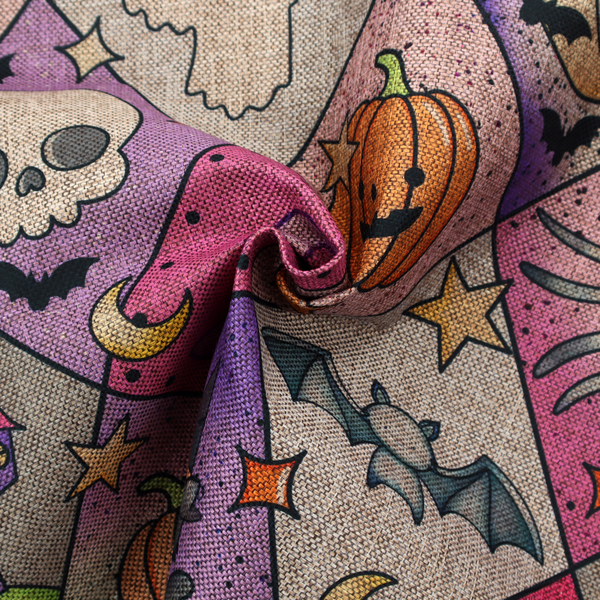 A Halloween-themed harlequin pattern fabric with diamond-shaped sections in purple, pink, and beige, featuring cartoon illustrations of Jack-o'-lanterns, a witch's cat, ghosts, bats, skulls, spiders, stars, and crescent moons.