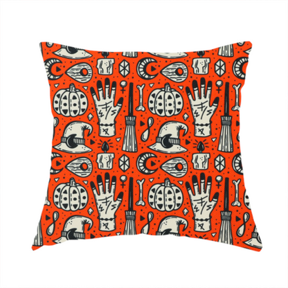 The fabric used to create this handmade cushion is an orange Halloween fabric patterned with repeating black and white illustrations of patterned pumpkins, mystical hands with symbols, witch hats with crescent moons, brooms, candles, bones, and planchettes.