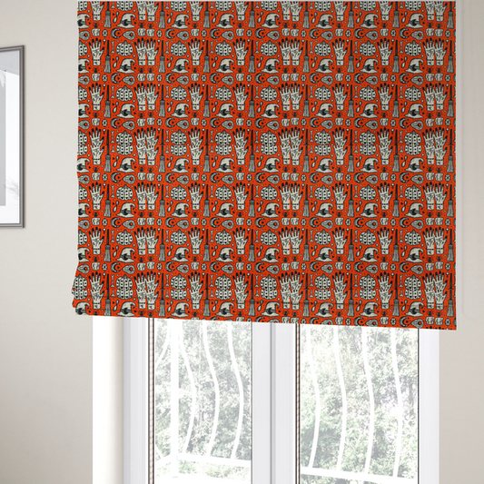 The fabric used to create these Roman blinds is an orange Halloween fabric patterned with repeating black and white illustrations of patterned pumpkins, mystical hands with symbols, witch hats with crescent moons, brooms, candles, bones, and planchettes.