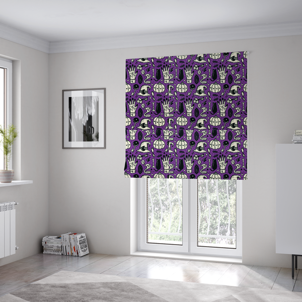The fabric used to create these Roman blinds is a purple Halloween fabric patterned with repeating black and cream illustrations of pumpkins, witch hats, black cats, mystical marked hands, snakes, keys, bones, and crystals.
