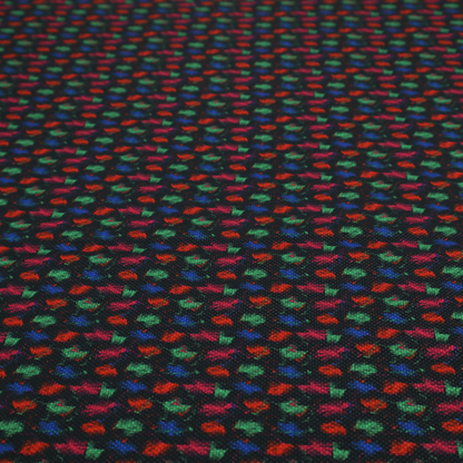 A textured tweed-style fabric featuring a dark background interwoven with dense specks of vibrant red, green, and blue flecks.
