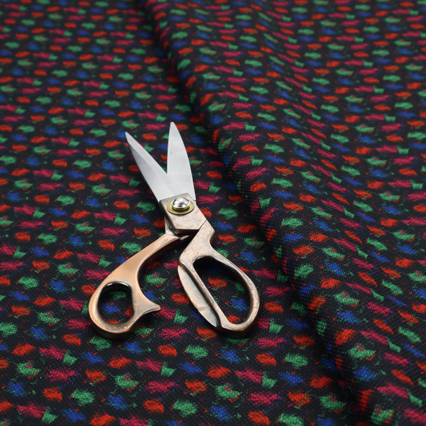 A textured tweed-style fabric featuring a dark background interwoven with dense specks of vibrant red, green, and blue flecks.