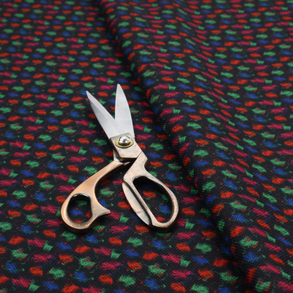 A textured tweed-style fabric featuring a dark background interwoven with dense specks of vibrant red, green, and blue flecks.
