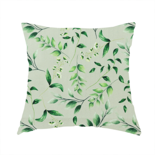 The fabric used to create this handmade cushion is a watercolour botanical fabric featuring a repeating pattern of leafy green branches and delicate white blossoms on a light sage-grey twill background.