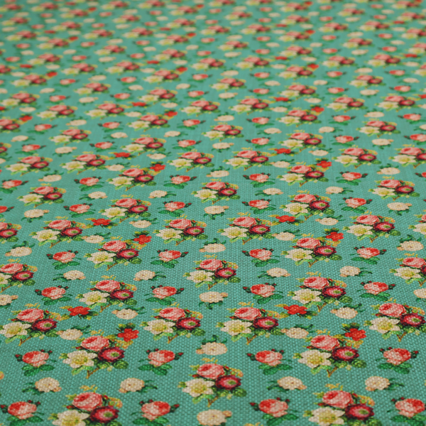 A charming repeating pattern of small bouquets featuring pink and red roses paired with white blossoms and green leaves set against a textured teal background.