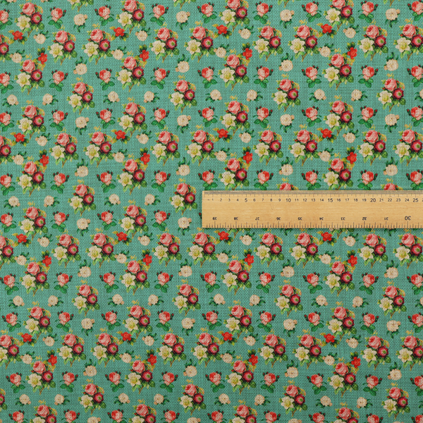 A charming repeating pattern of small bouquets featuring pink and red roses paired with white blossoms and green leaves set against a textured teal background.