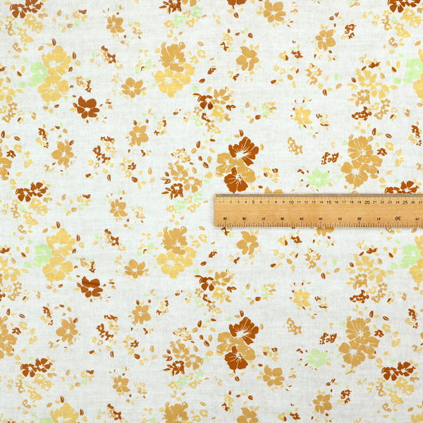 A delicate, ditsy floral repeating pattern on an off-white background featuring small clusters of flowers and leaves in shades of yellow, gold, brown, and pale green.