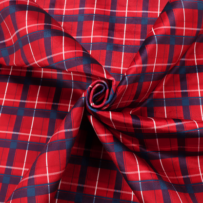 A vibrant red plaid and tartan pattern featuring intersecting dark blue and white stripes over a bold red background.
