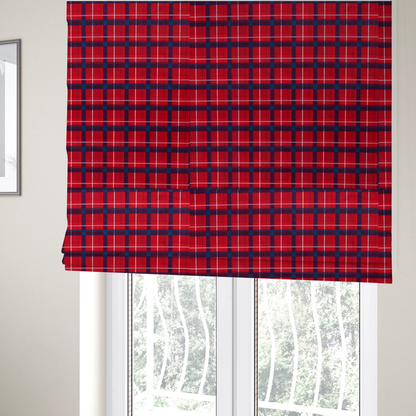 The fabric used to create these Roman blinds is a vibrant red plaid and tartan pattern featuring intersecting dark blue and white stripes over a bold red background.