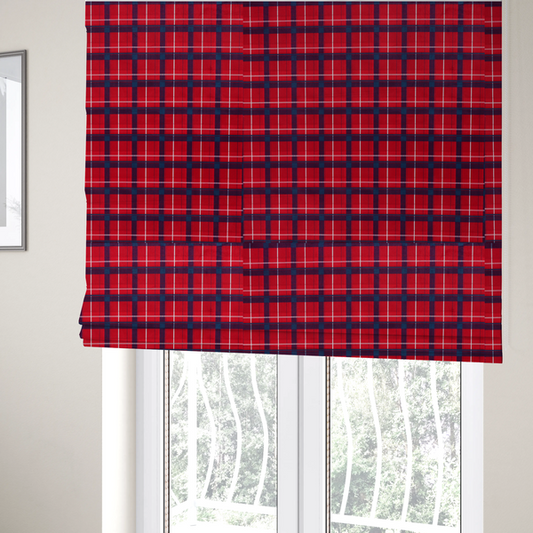 The fabric used to create these Roman blinds is a vibrant red plaid and tartan pattern featuring intersecting dark blue and white stripes over a bold red background.