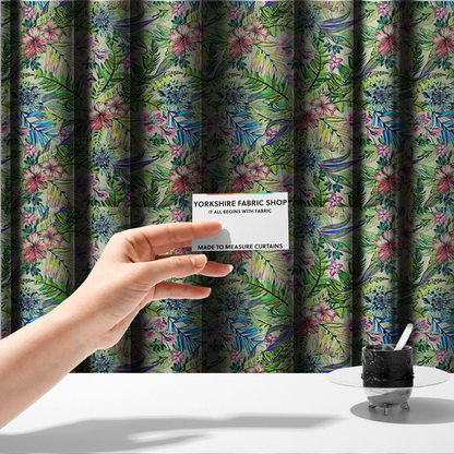 The fabric used to create these made-to-measure curtains is a vibrant, dense tropical pattern featuring colourful hibiscus and orchid flowers, spiky blue and white blooms, and lush green and blue palm leaves.