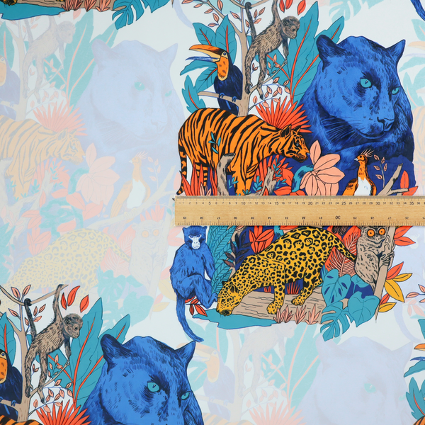 A colourful and vibrant jungle pattern on a pale background featuring a blue panther, tigers, leopards, monkeys, toucans, and lush tropical flora.