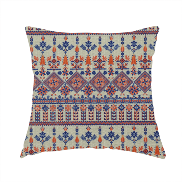 The fabric used to create this handmade cushion is an intricate folk-inspired fabric featuring horizontal bands of geometric diamonds, stylized birds, and floral motifs in navy blue and rust orange on a beige background.