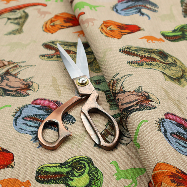 Several distinct dinosaur heads are scattered across the pattern, including detailed illustrations of a Triceratops with horns, a green Tyrannosaurus rex with textured skin, a long-snouted Parasaurolophus with a prominent crest, a blue-headed theropod with a pink crest, an orange-headed ceratopsian, and a Spinosaurus with a crocodile-like snout.