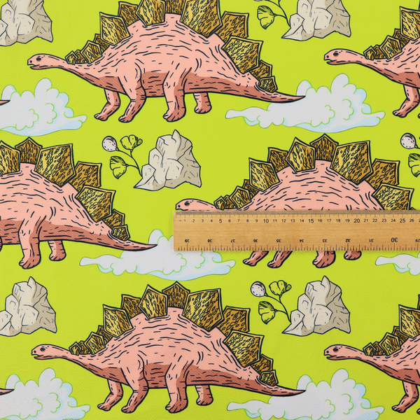 A repeating pattern on a vibrant green background featuring pink Stegosaurus dinosaurs with golden plates, interspersed with light grey rocks, fluffy white clouds, and small green sprigs.
