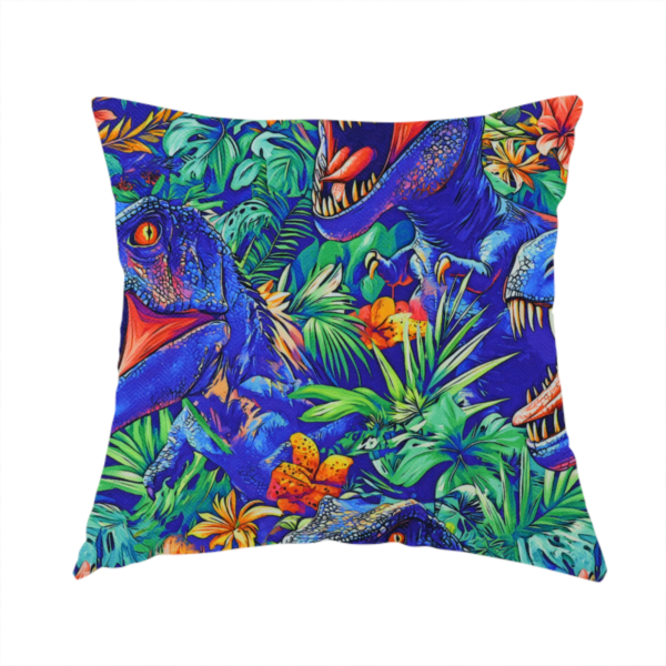 The fabric used to create this handmade cushion is a vibrant, repeating pattern on a rich blue background featuring blue-and-purple Tyrannosaurus rex heads with open jaws and sharp teeth, surrounded by lush green tropical foliage, orange flowers, and plants.