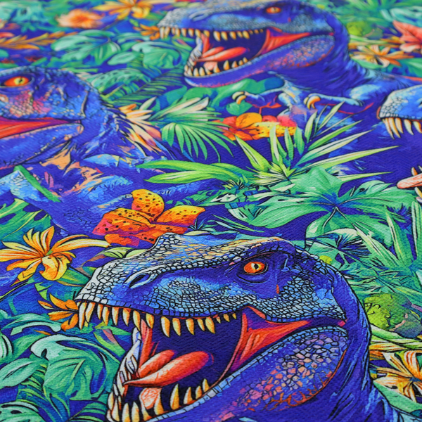 A vibrant, repeating pattern on a rich blue background featuring blue-and-purple Tyrannosaurus rex heads with open jaws and sharp teeth, surrounded by lush green tropical foliage, orange flowers, and plants.