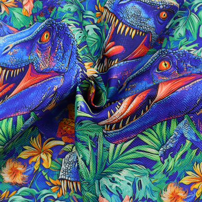 A vibrant, repeating pattern on a rich blue background featuring blue-and-purple Tyrannosaurus rex heads with open jaws and sharp teeth, surrounded by lush green tropical foliage, orange flowers, and plants.