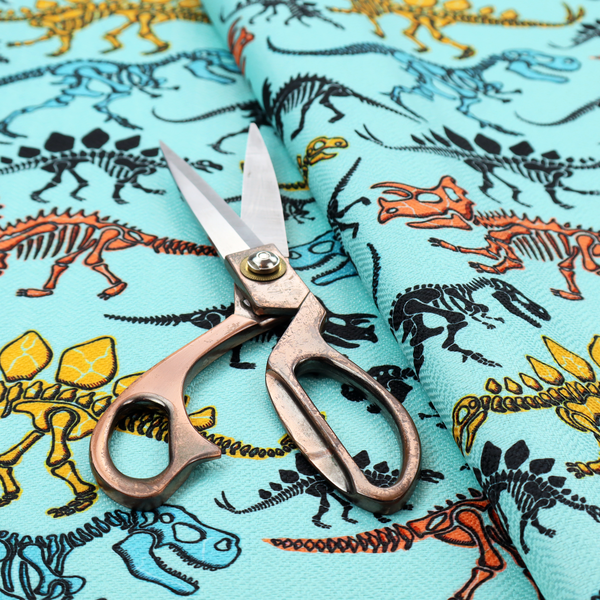 A repeating pattern on a light blue background featuring colourful dinosaur skeletons in yellow, orange, blue, and black, depicting various species including Stegosaurus, Triceratops, and Tyrannosaurus rex.