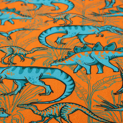 A repeating pattern on a bright orange background featuring blue dinosaurs, including Stegosaurus, T-Rex, and pterosaurs, set against a backdrop of palm leaves and tropical foliage.