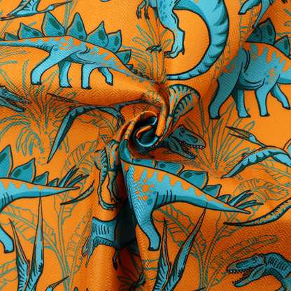 A repeating pattern on a bright orange background featuring blue dinosaurs, including Stegosaurus, T-Rex, and pterosaurs, set against a backdrop of palm leaves and tropical foliage.