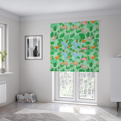 The fabric used to create these Roman blinds is a repeating pattern on a light green background featuring colourful illustrated dinosaurs—including blue T-Rexes, pink Stegosauruses, beige Triceratopses, and orange sauropods—surrounded by green palm trees, bushes, and tropical foliage.