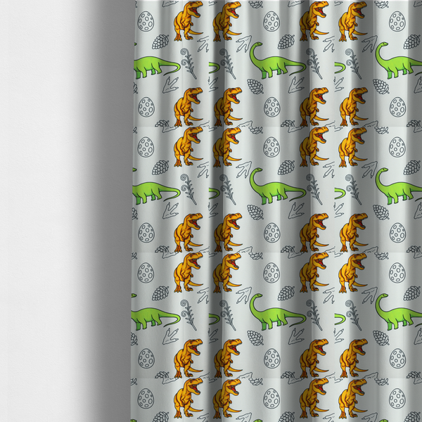 The fabric used to create these made-to-measure curtains is a repeating pattern on a light grey-blue background featuring orange Tyrannosaurus rex dinosaurs, a bright green long-necked sauropod, speckled dinosaur eggs, pinecones, footprints, and leafy sprigs.